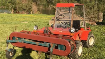 Červený svahový traktor Reform Metrac na louce