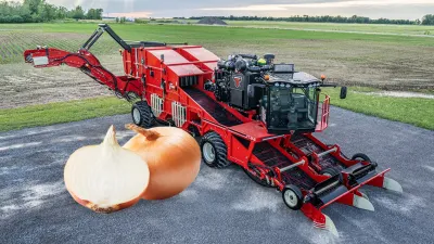 Mechanizovaný sklízeč cibule s cibulemi v popředí