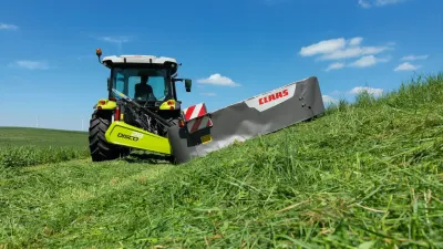 Traktor se žacím strojem Claas Disco na louce