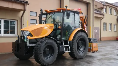 Oranžový traktor Zetor Proxima u budovy