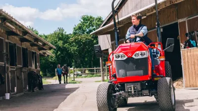 Kompaktní traktor Massey Ferguson u zemědělské budovy
