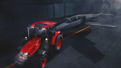 Červený traktor Zetor před tmavou budovou