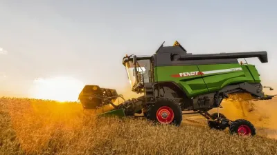 Sklízecí mlátička Fendt na poli za soumraku