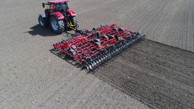 Traktor táhne kultivátor Kverneland Tiger po poli
