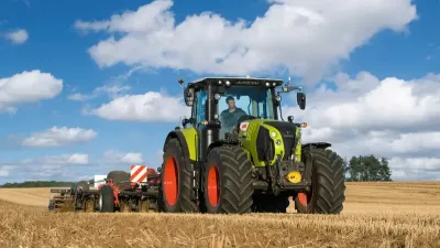 Traktor Claas Arion na poli pod modrou oblohou