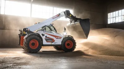 Teleskopický manipulátor Bobcat nabírá materiál ve skladu