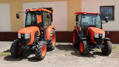 Dva oranžové kompaktní traktory Kubota