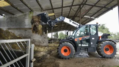 Teleskopický nakladač Bobcat nakládá krmivo v hale