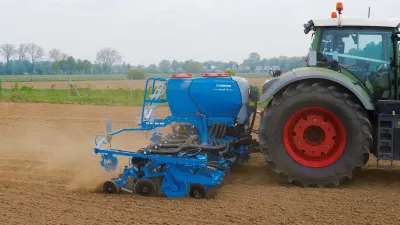 Traktor s modrým secím strojem Lemken Azurit na poli.