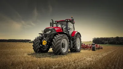 Červený traktor Case IH s nářadím na poli