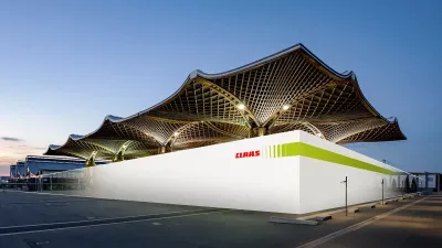 Výstavní pavilon CLAAS s výraznou střechou v podvečerním světle.