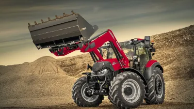 Červený traktor Case IH s čelním nakladačem a zvednutou lopatou.