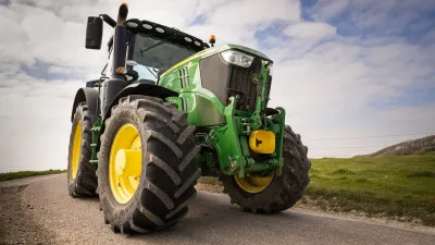 Zelený traktor John Deere s velkými pneumatikami Continental.