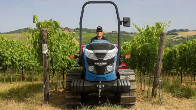 Modrý pásový traktor Landini Trekker 4 ve vinici