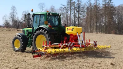 Traktor John Deere s lučními branami APV na louce