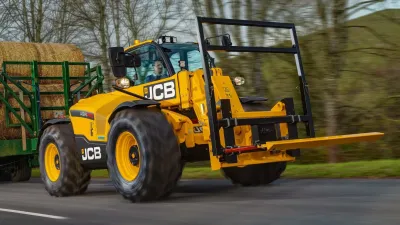 Žlutý teleskopický nakladač JCB 542-70 AGRI Pro u balíků