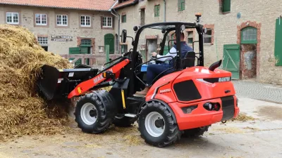 Červený kloubový nakladač Manitou při práci