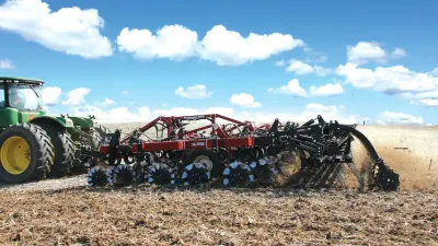 Traktor s diskovým podmítačem při zpracování půdy