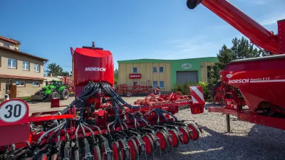 Červené secí stroje Horsch vystavené před provozovnou STAGRA.