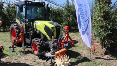 Traktor CLAAS NEXOS s nářadím pro práci v ovocném sadu.