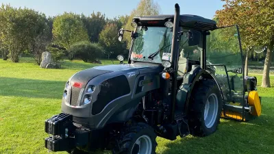 Tmavý traktor Carraro Agricube Pro stojí na trávníku.