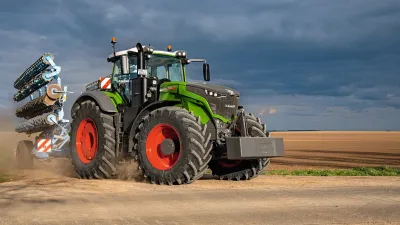 Velký zelený traktor Fendt s červenými koly na poli.