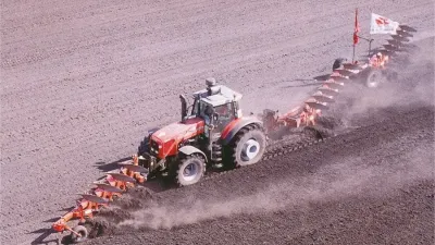 Traktor Massey Ferguson při rekordní orbě s dlouhou soupravou pluhů.
