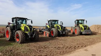 Tři traktory CLAAS Xerion vystavené na poli.