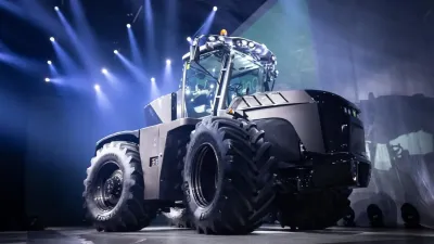 Hybridní traktor AUGA M1 při prezentaci na pódiu.