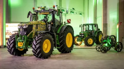 Jubilejní traktor John Deere vystavený v hale.