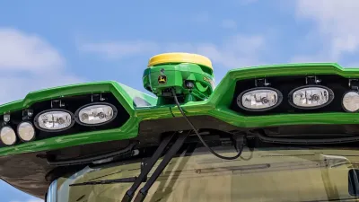 Přijímač John Deere StarFire 7000 na střeše stroje.
