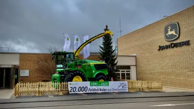 Samojízdná řezačka John Deere vystavená před závodem.