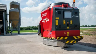 Červený robotický krmný vůz Trioliet před silami