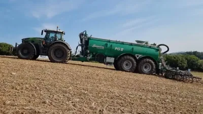 Traktor se zelenou cisternou Samson na poli