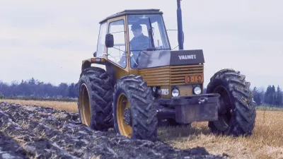 Starší žlutý traktor Valmet při práci na poli