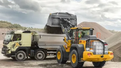Elektrický kolový nakladač Volvo nakládá materiál na nákladní vůz