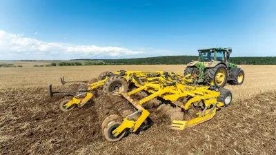 Traktor se žlutým diskovým podmítačem BEDNAR na poli