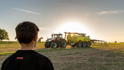 Traktor s aplikační cisternou Pichon na poli při západu slunce