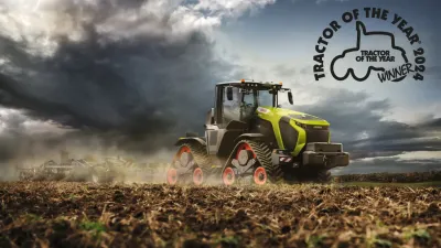 Pásový traktor Claas Xerion na poli s logem Traktor roku 2024.