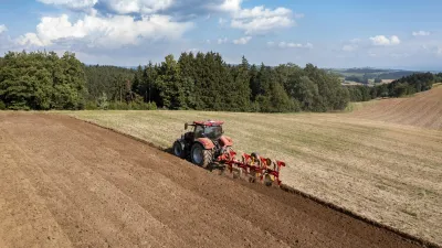 Traktor s neseným pluhem Pöttinger Servo 3000 při orbě pole