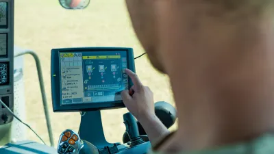 Obsluha nastavuje dotykový displej secího stroje v kabině traktoru
