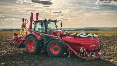 Červený traktor se secím strojem Kverneland na poli