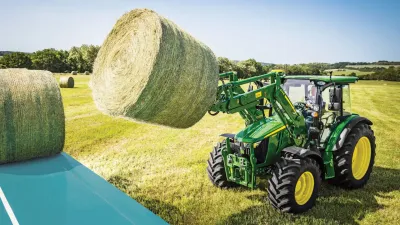 traktor John Deere 5M zvedající balík za pomoci čelního nakladače