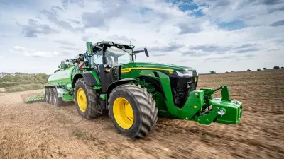 Traktor John Deere s cisternou na poli