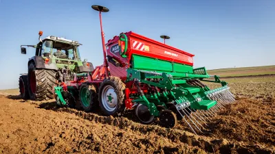 Secí stroj Agro-Masz za traktorem na poli