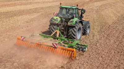 Traktor s diskovým podmítačem Amazone Catros na poli