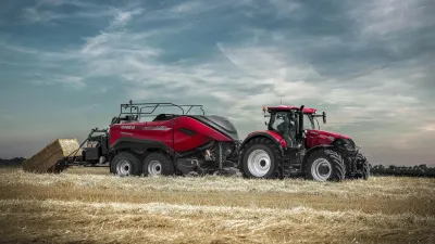 Traktor Case IH s lisem na hranaté balíky na poli.