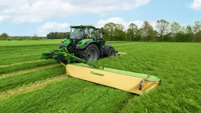Traktor se žacím strojem Krone EasyCut seče louku.