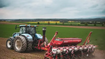 Traktor s přesným secím strojem Kverneland na poli.