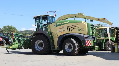 Zelená sklízecí řezačka Krone BiG X na dvoře.
